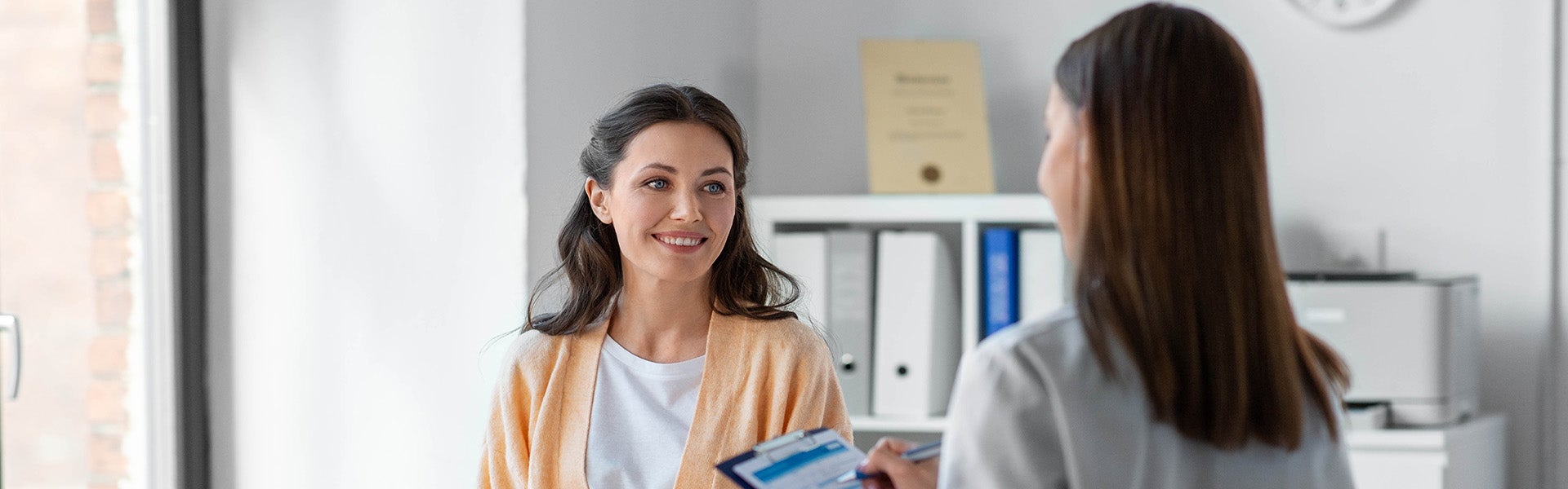 Client speaking with a skincare professional during a consultation at a modern aesthetic clinic.