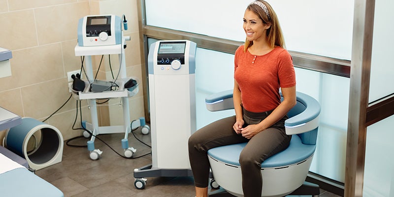Young happy woman having non-invasive treatment for urinary incontinence at the clinic.